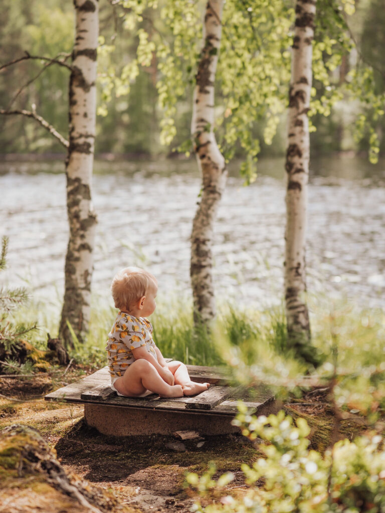 Lapsi istuu kiven päällä kotimaiset Moomin Baby -vaipat jalassa